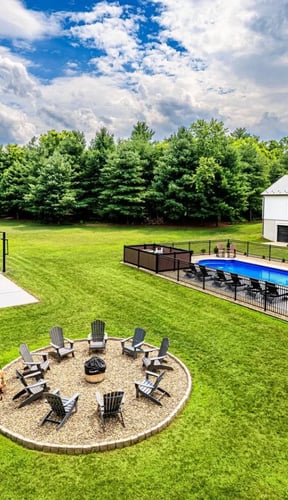 Aerial view of property with fire pit circle, pickleball court, and pool on a sunny day
